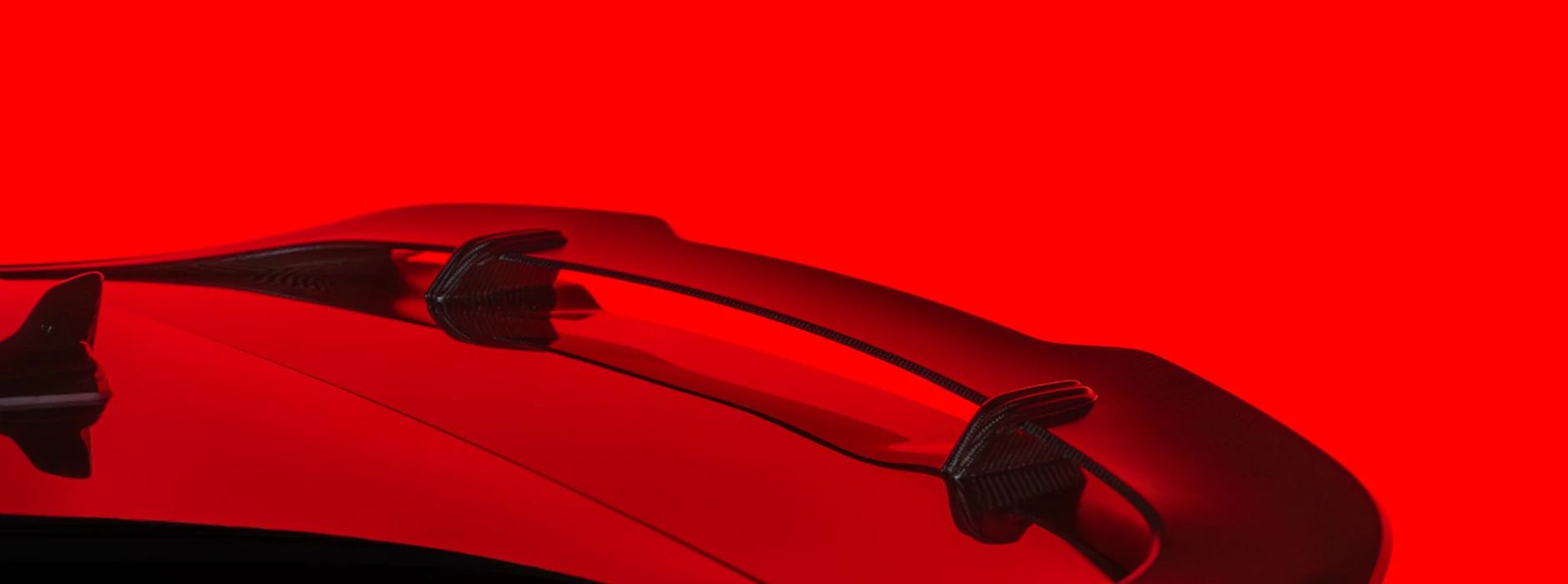 Aileron d’une voiture sport sous un éclairage rouge